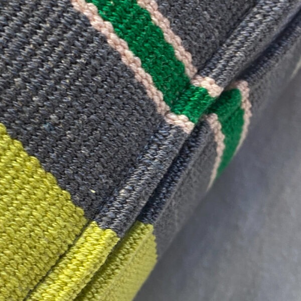 Detailansicht Sofakissen mit Reißverschluss. unregelmäßig hellgrün, grau, weiß und grün gestreift
