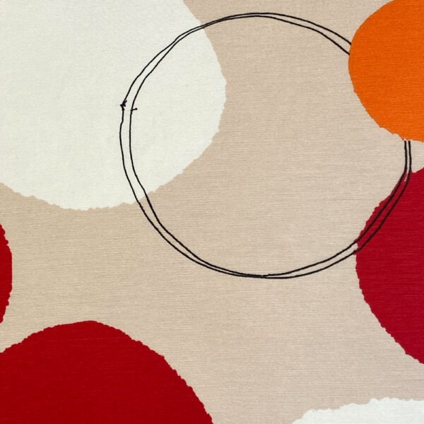 Beigefarbener Stoff, lose bedruckt mit roten, orangen und weißen unterschiedlich großen Punkten und schwarz umrandeten Kreisen.