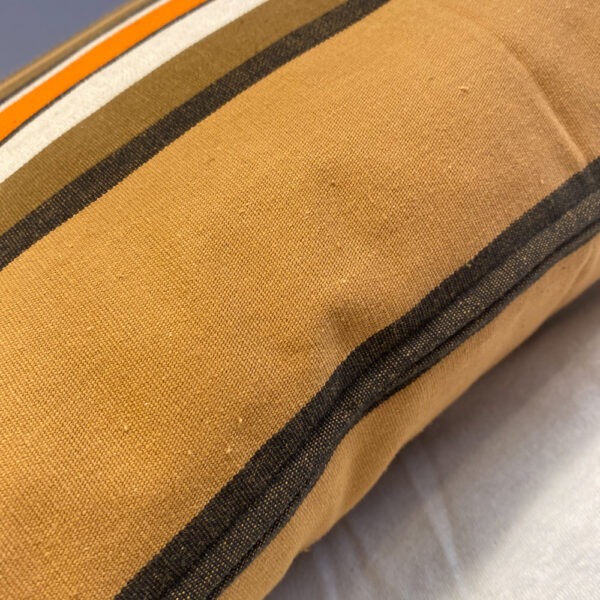 Detailansicht mit Reißverschluss.Polster aus hellbraun, dunkelbraun, orangen weiß gestreiftem 70er Jahre Stoff. Die Streifen sind unregelmäßig.