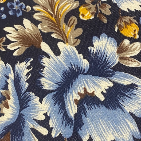 Stoffdetail,schwarzgrundiges Vintage-Polster mit üppig aufgedruckten Blüten und Eichenblättern in braun, weiß, hellblau, gelb