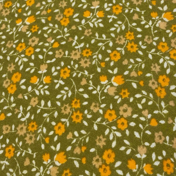 Detailansicht hell moosgrünfarbenes Vintage-Kissen mit aufgedruckten kleinen Streublümchen in Orange und weißen Stielen