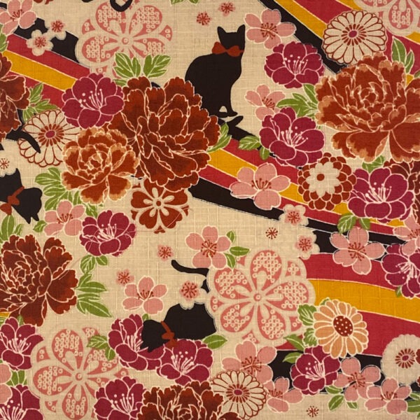Detailansicht Vintage Kimonostoff bedruckt mit verschiedenen in mehreren Rottönen gehaltenen Blüten, gelborange-schwarz-roséfarbenen, nur teilweise sichtbaren, Banderolen und kleinen schwarzen Katzen mit roter Schleife um den Hals
