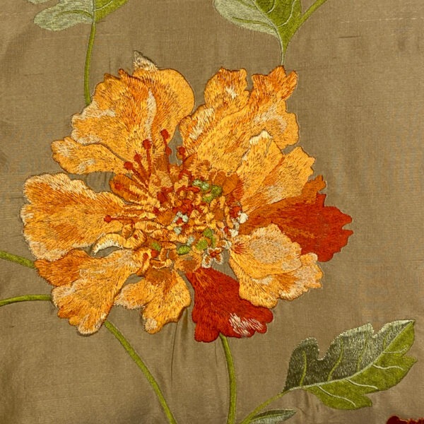 Detailansicht, seidiges Sofakissen in hellem goldcaramell mit Einzelnen aufgestickten orangen-rot schillernden mohnartigen Blüten , hellgrünen Blättern und Stielen