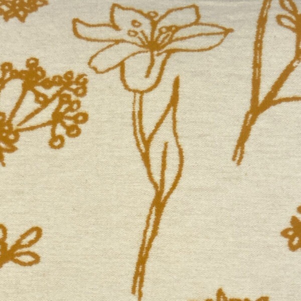 Detail, Sofakissen aus flauschigem wollweißen Stoff mit lose verteilten ockerfarbenen Blumen mit Stiel