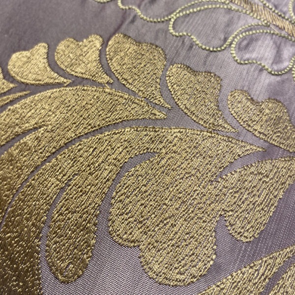Detail, Seidenkissen in gedecktem rosélila mit Farbverlauf ins dunklere Lila, bestickt mit bronce-goldfarbenen großen Blättern